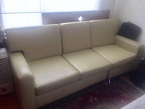 Sala consta de un sofá de tres puestos, una silla y mesa de